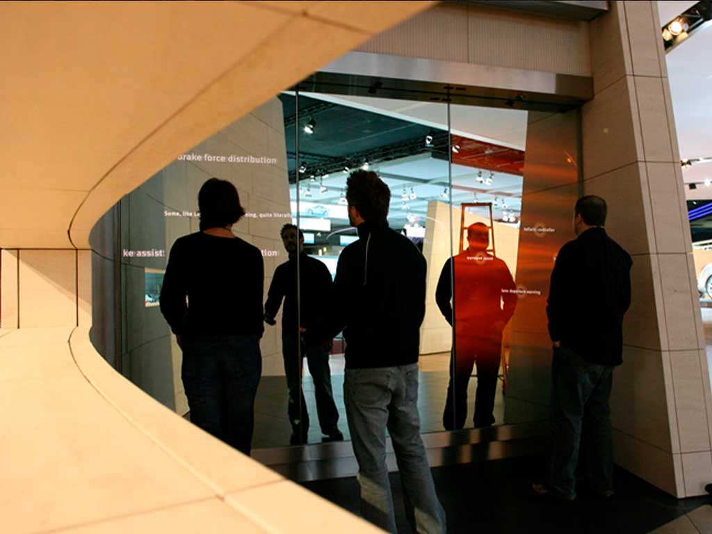 Nissan standındaki dokunmatik ayna uygulamasını inceleyen ziyaretçiler