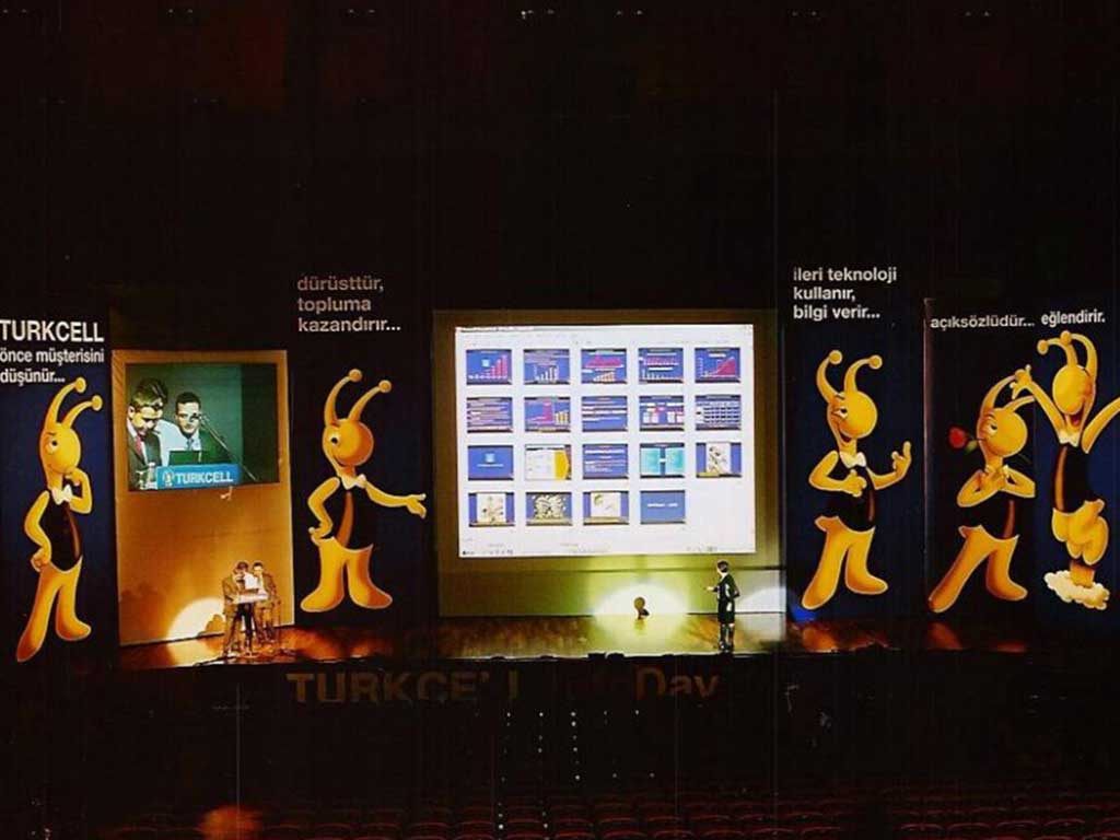 Turkcell InfoDay sahnesi, dev ekran ve maskot figürleri